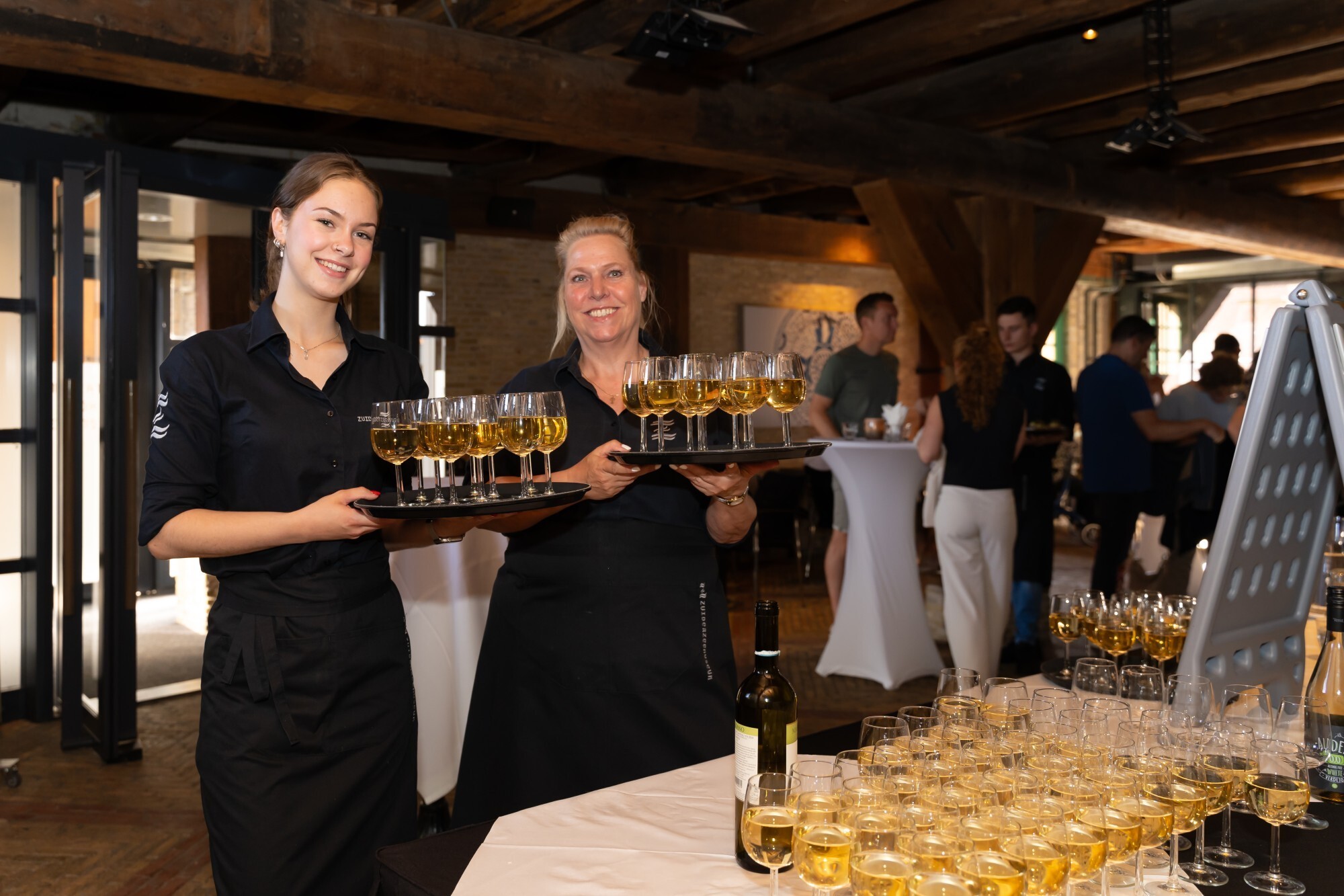 bediening van het Amsterdamse huis houden dienbladen met wijn vast.