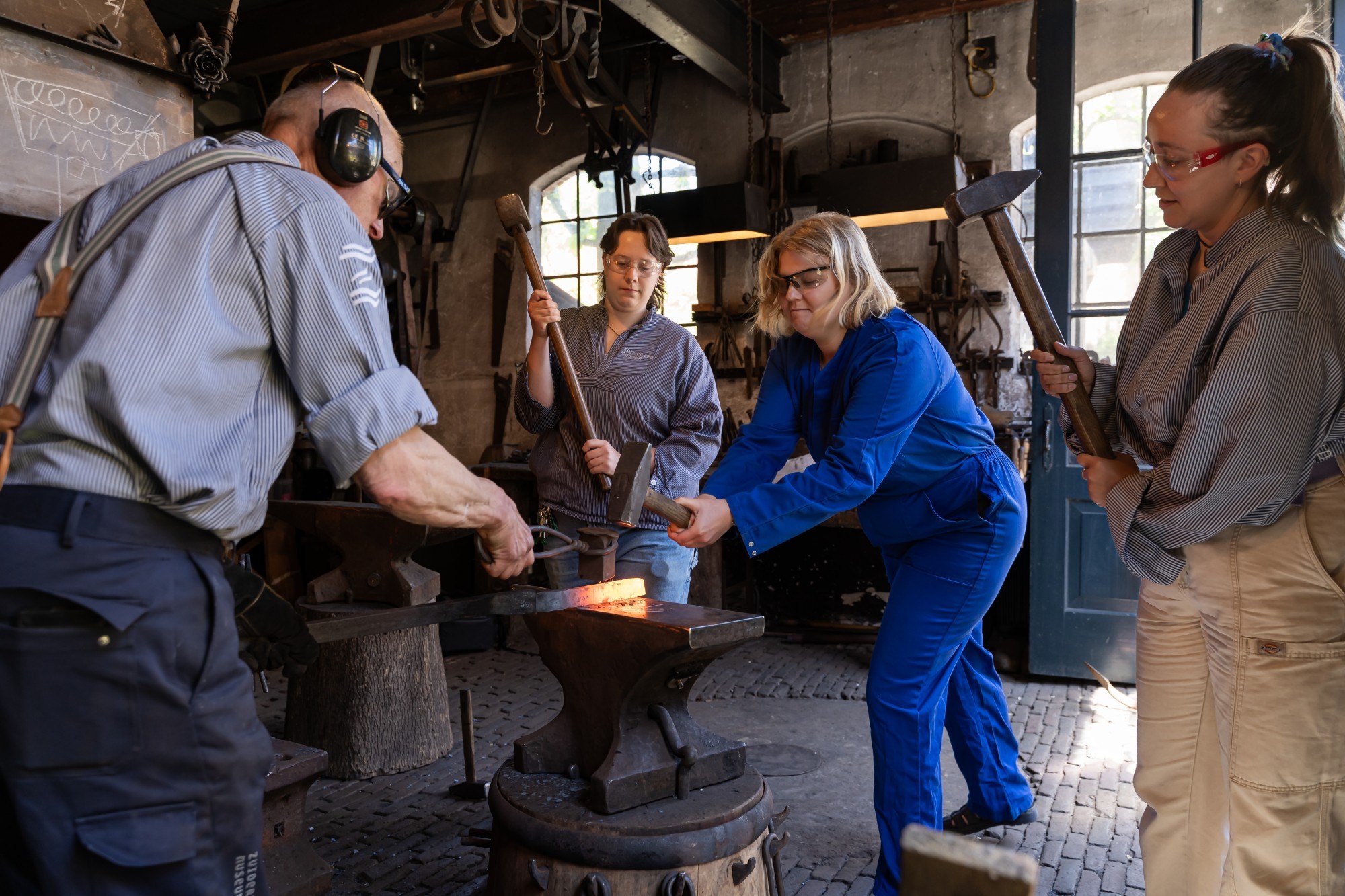 Foto van mensen die de smid helpen