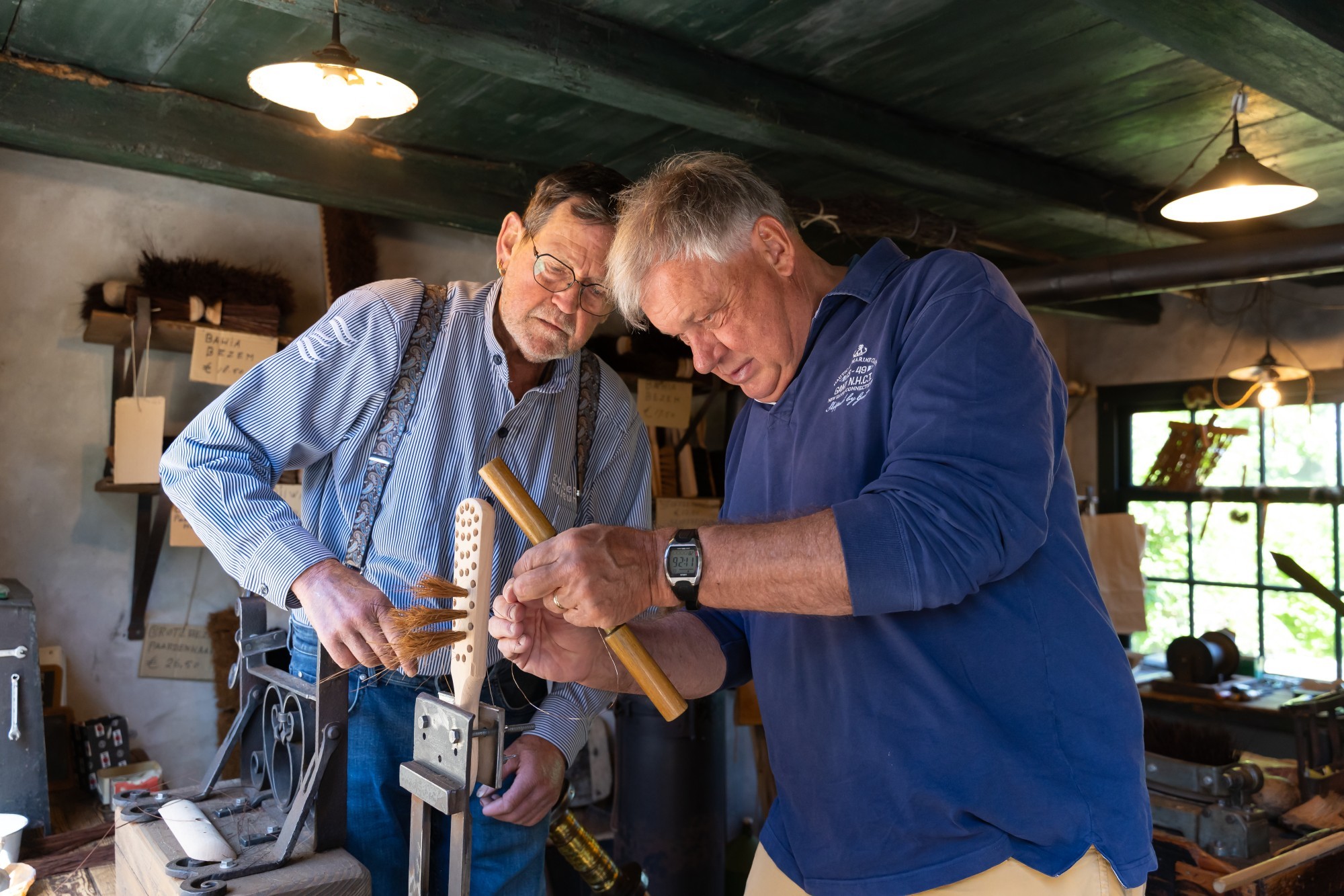 Foto van man die de borstelmaker helpt