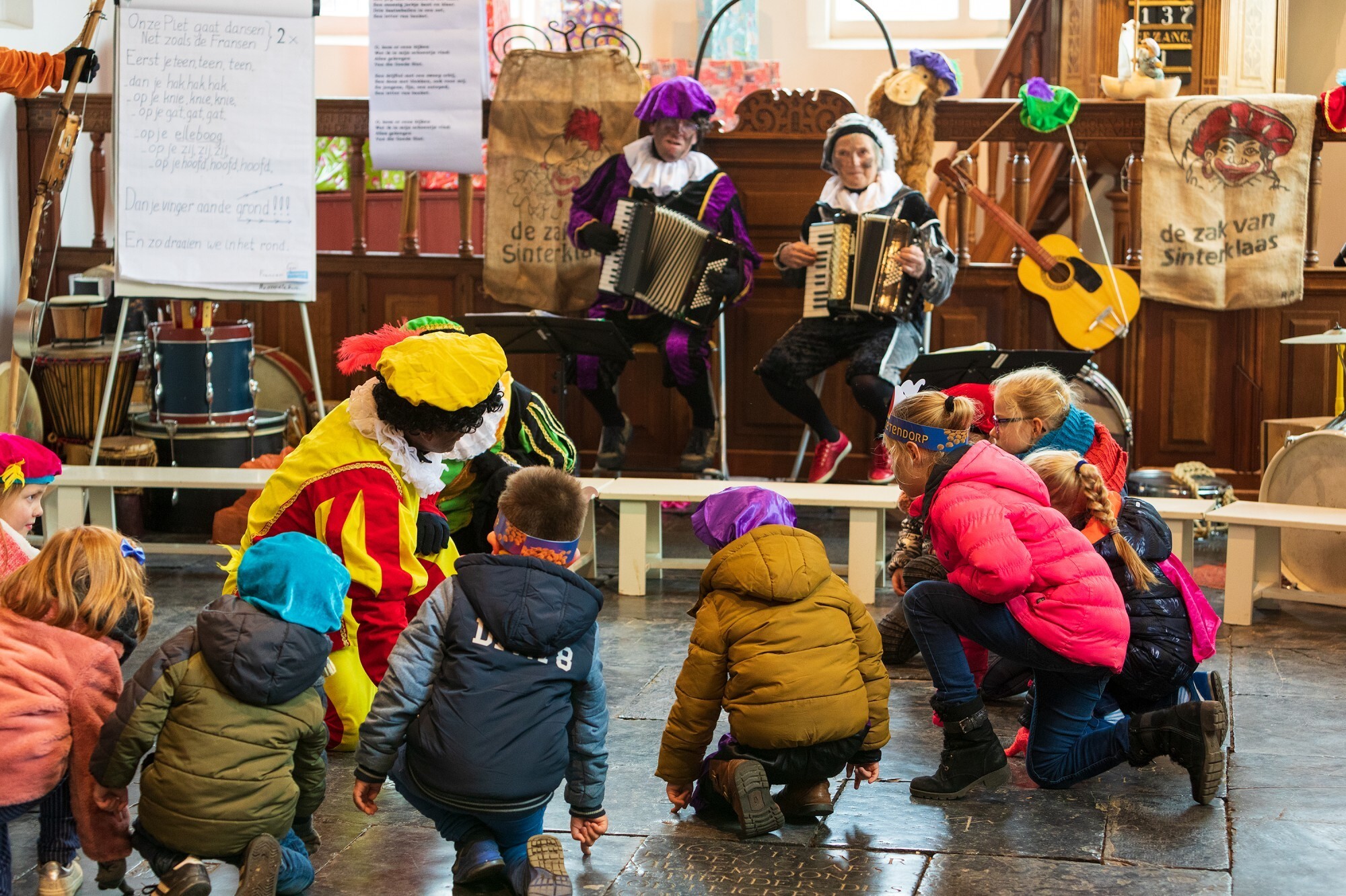 Pietenband met kinderen die samen met pietjes dansen.