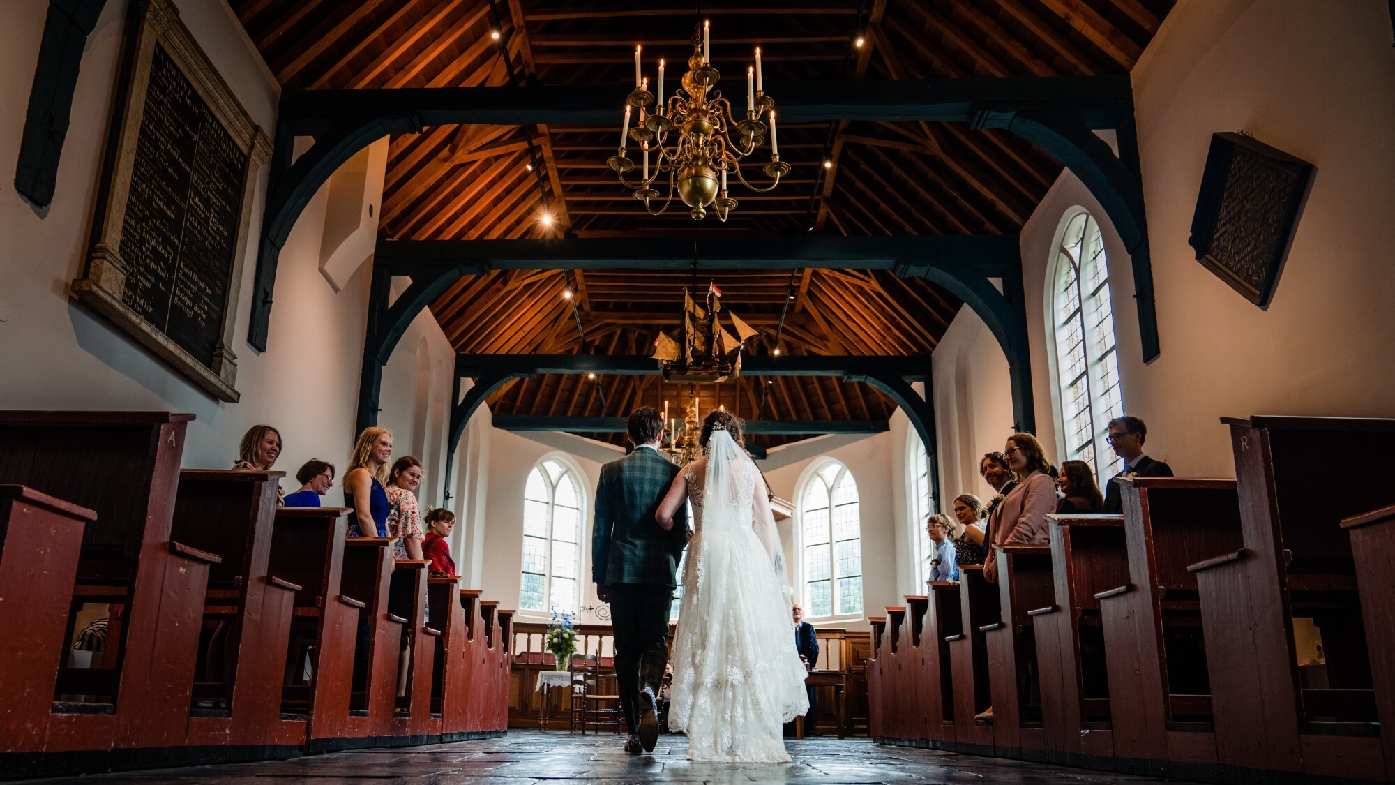 Het bruidspaar loopt hand in hand door de kerk van ’t Zuiderzeedorp