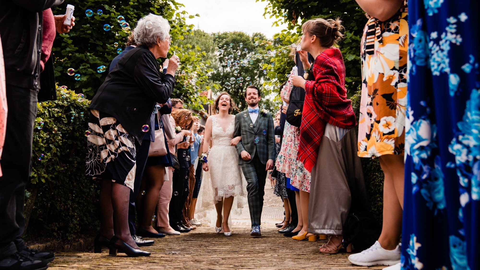 Bruidspaar lopen door bellenblaas bubbels