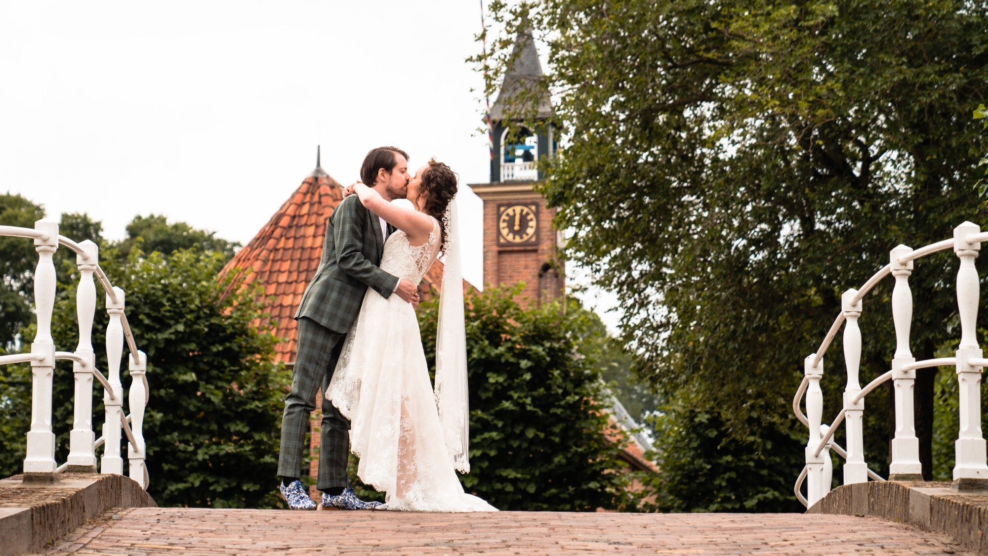 Bruidspaar geeft elkaar een kus op een brug in 't Zuiderzeemuseum