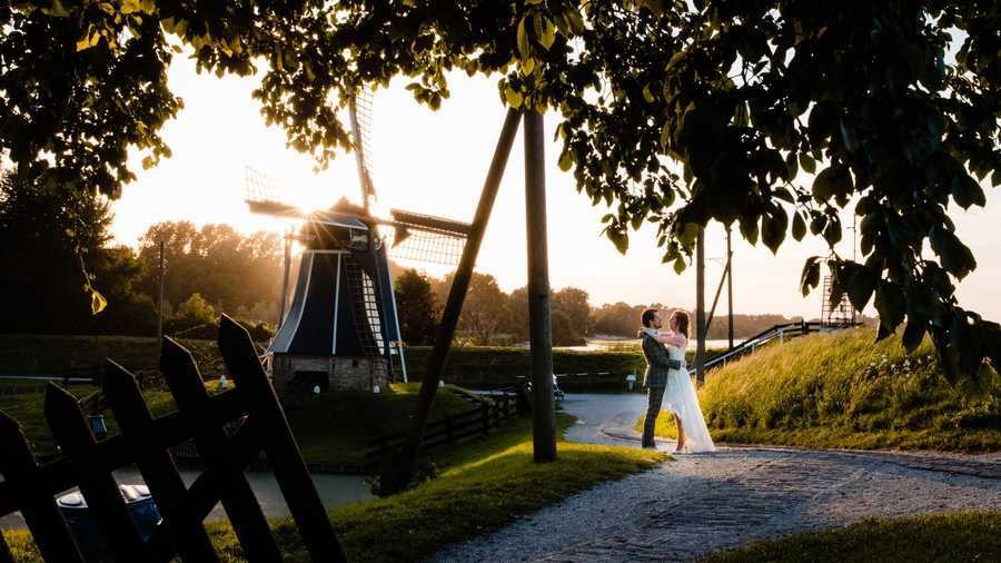 Het bruidspaar staat omarmd bij de molen in ’t Zuiderzeedorp.