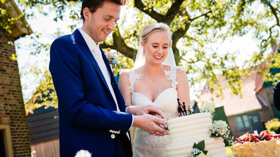 Bruidspaar is taart aan het snijden in 't Zuiderzeedorp