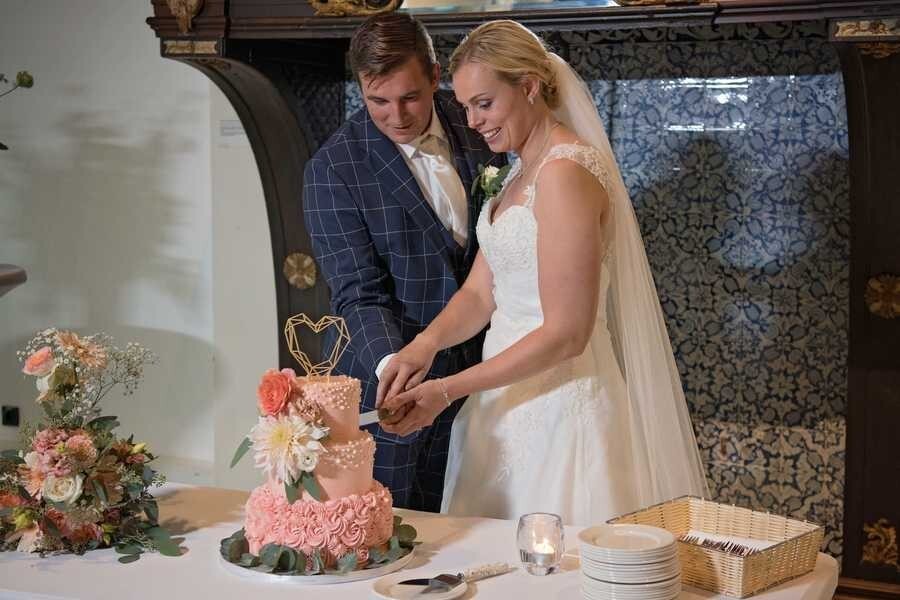 Bruidspaar is taart aan het snijden in het Amsterdamse Huis