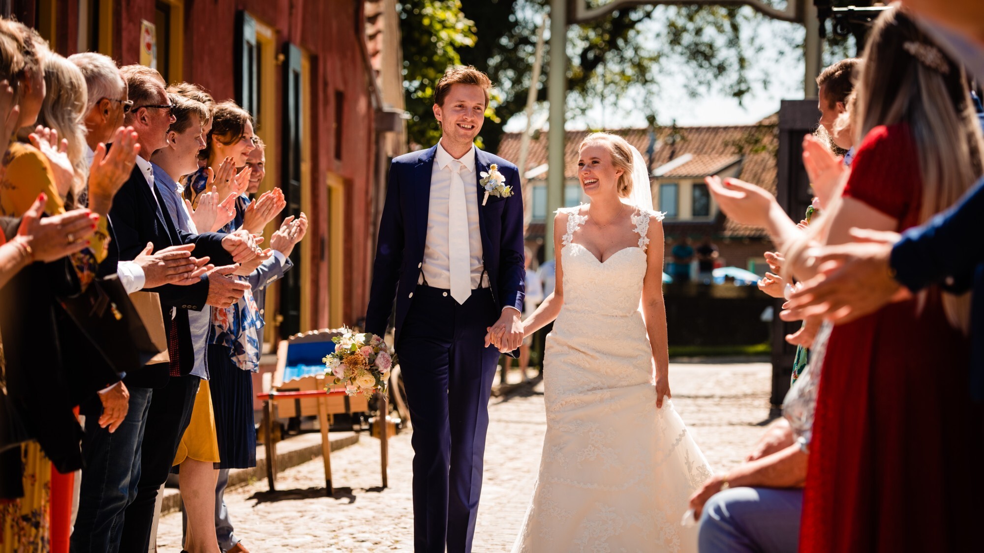 Bruidspaar loopt  hand in hand door 't Zuiderzeedorp