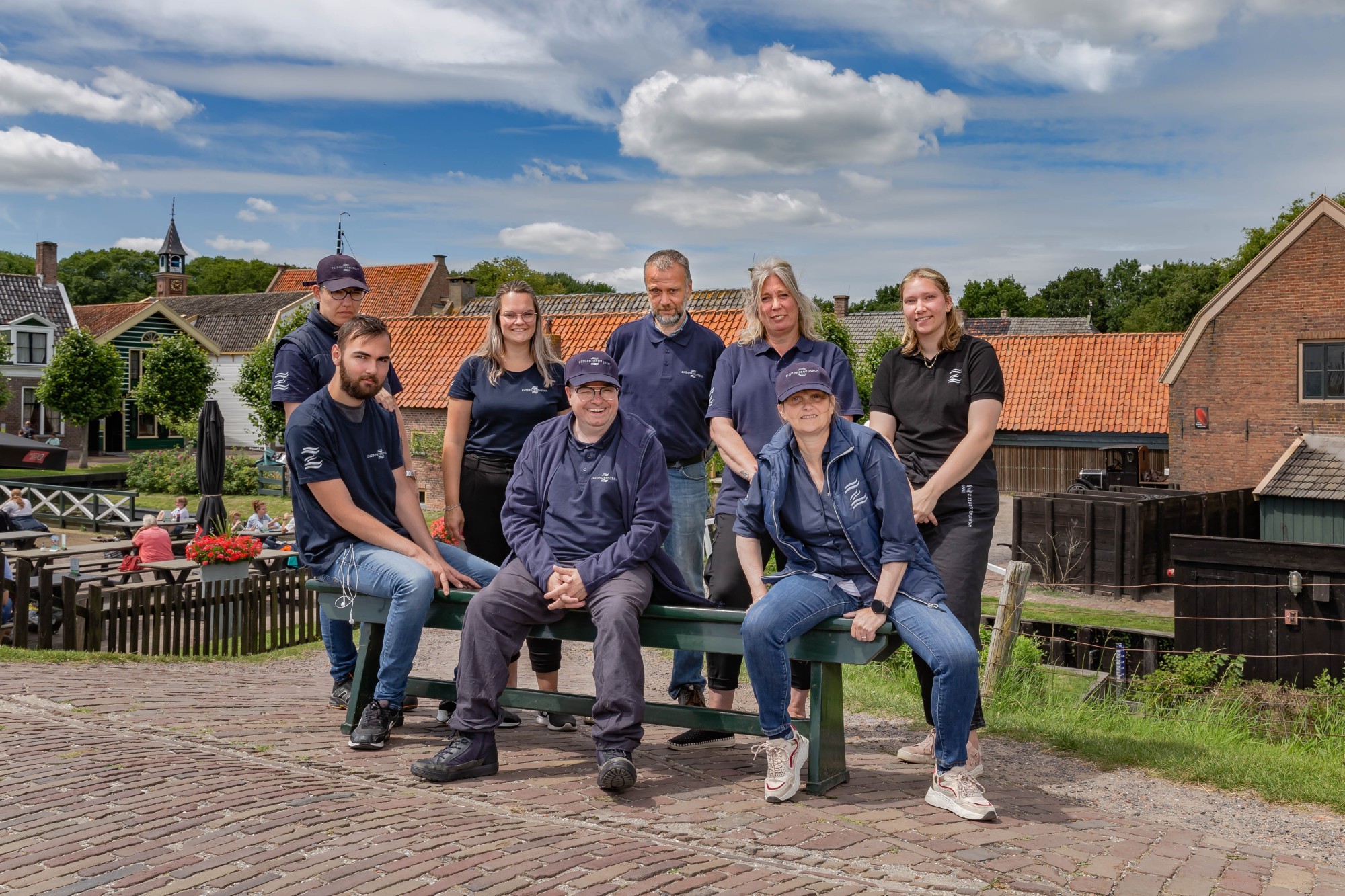 De Philadelphia groep, ze zitten en staan op een bankje op de dijk