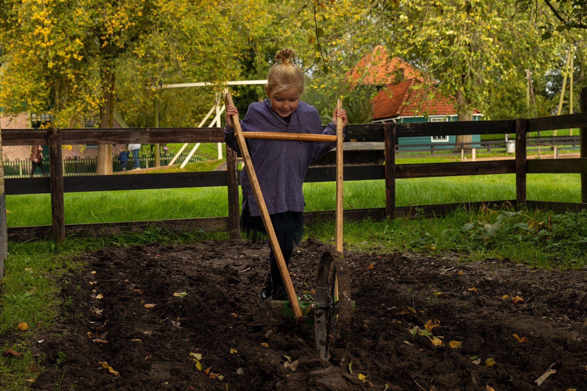 Meisje is het land aan het bewerken met een ploeg.