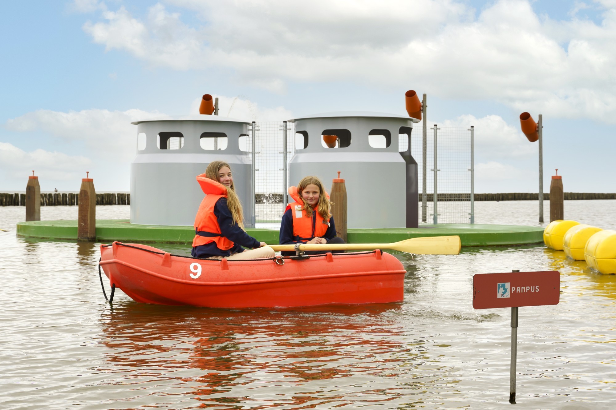 Twee meisjes in een roeibootje op het water.