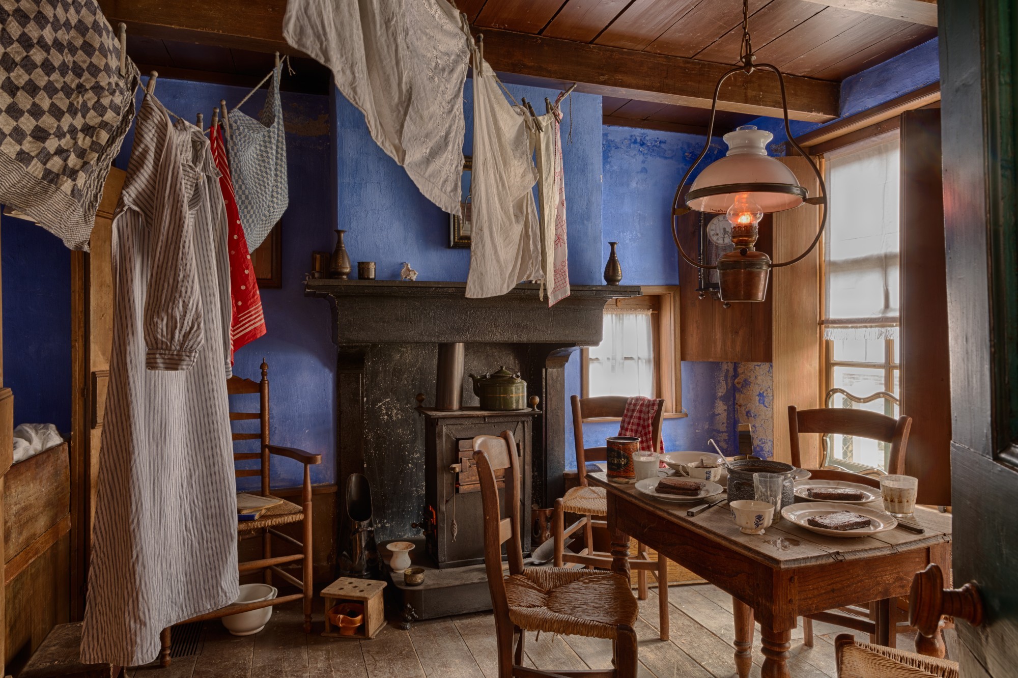 De woonkamer, waar de was te drogen hangt aan een lijn die langs de muur is gespannen.