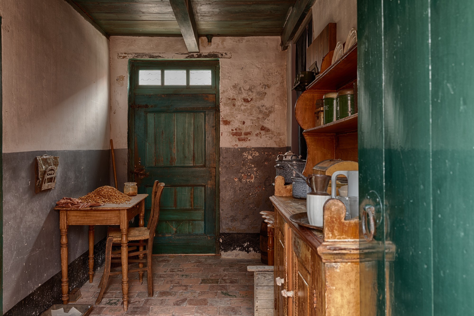 Een kleine keuken, waar een tafel vol met garnalen tegen de muur aanstaat.