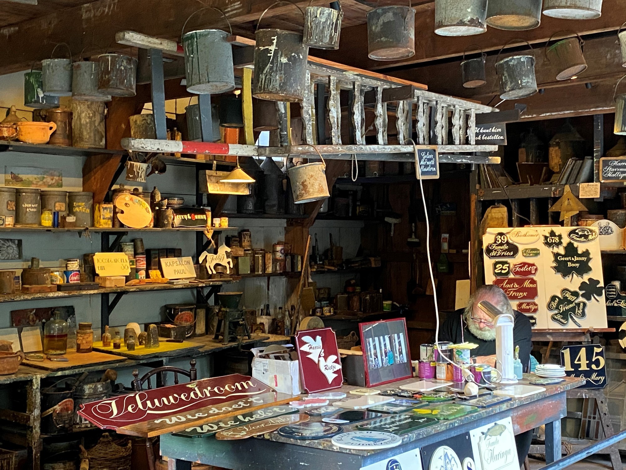 Het schilderatelier, waar een man druk bezig is met schilderen