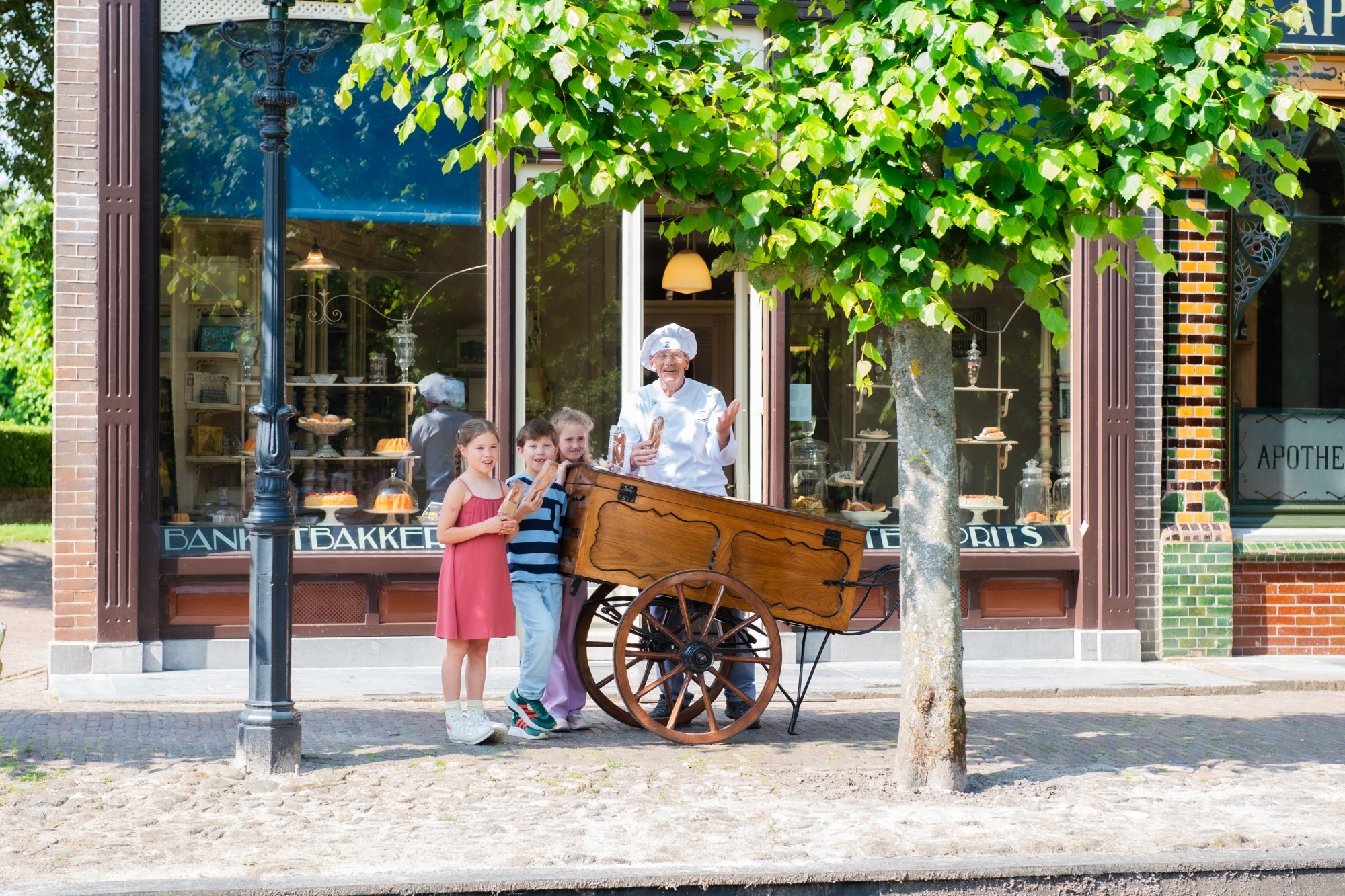 Bakker staat bij een kar met drie kinderen