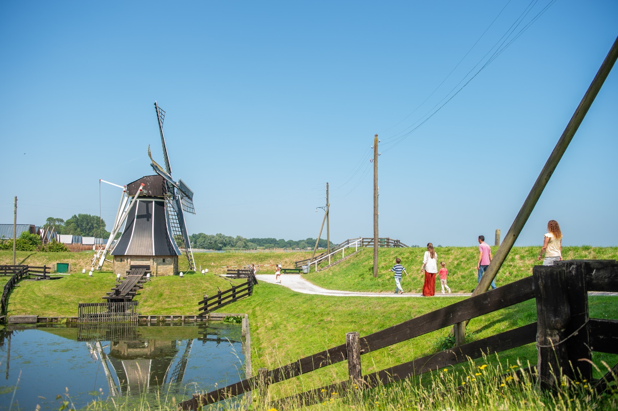 Parkgasten lopen langs de molen in 't Zuiderzeedorp.