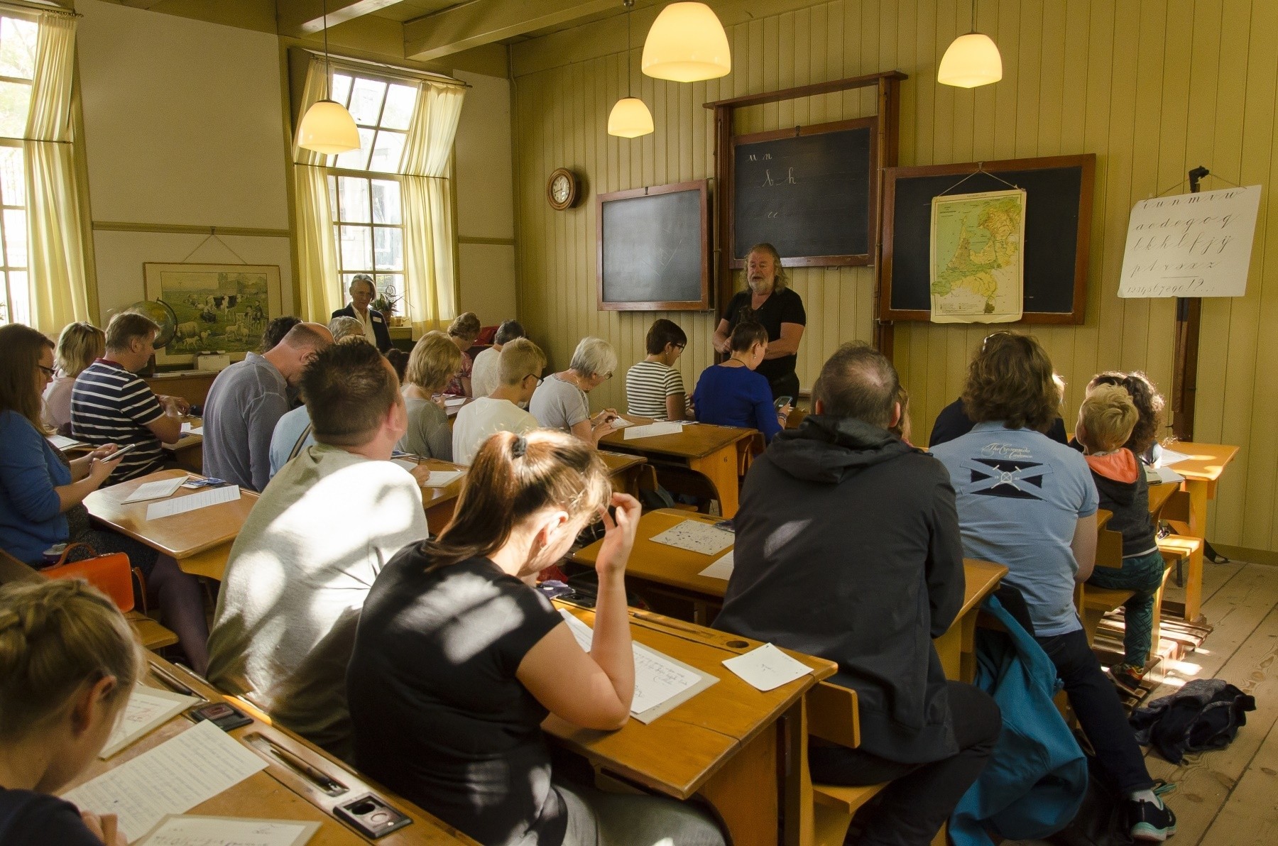 Een vol klaslokaal tijdens schrijfles, in het Kollumer schooltje