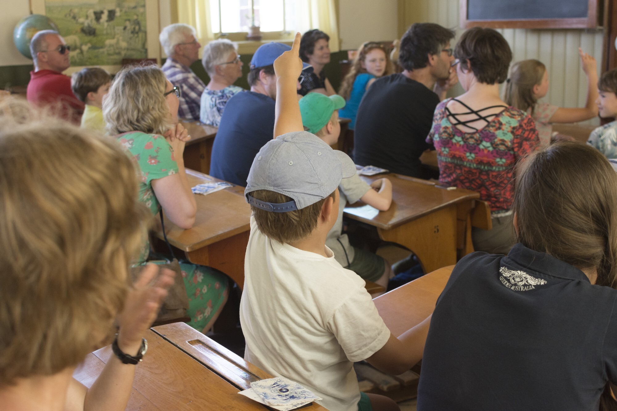 Een kind steekt zijn hand in de lucht tijdens een les in het Kollumer schooltje