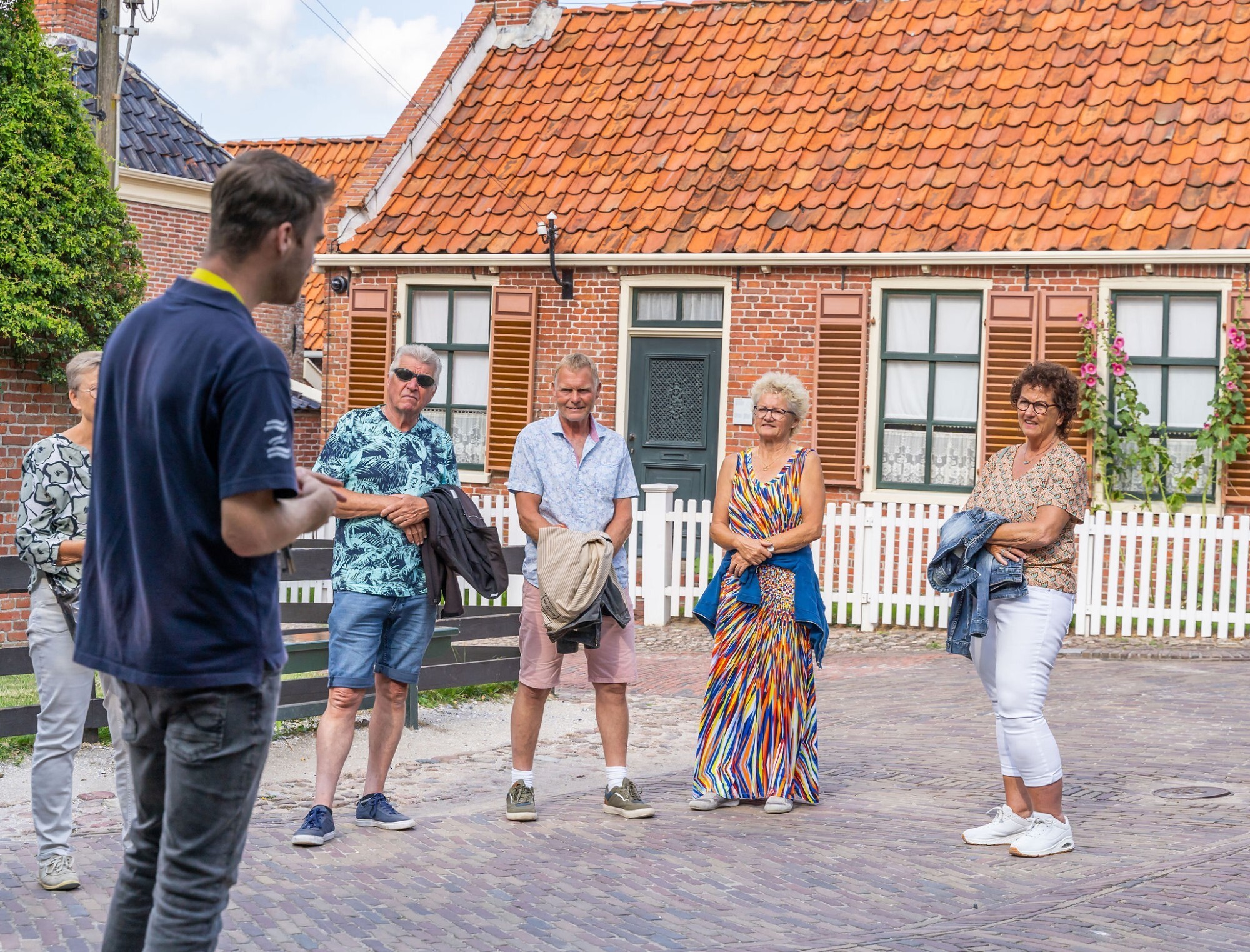 Een groep bezoekers krijgt uitleg van een museumdocent, in 't Zuiderzeedorp