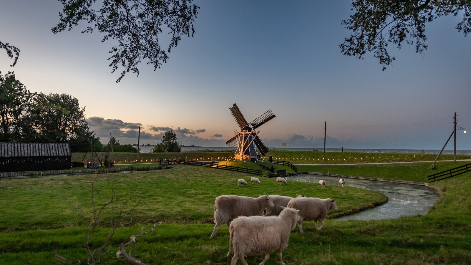 De molen van 't Zuiderzeedorp is zichtbaar tijdens zonsondergang.