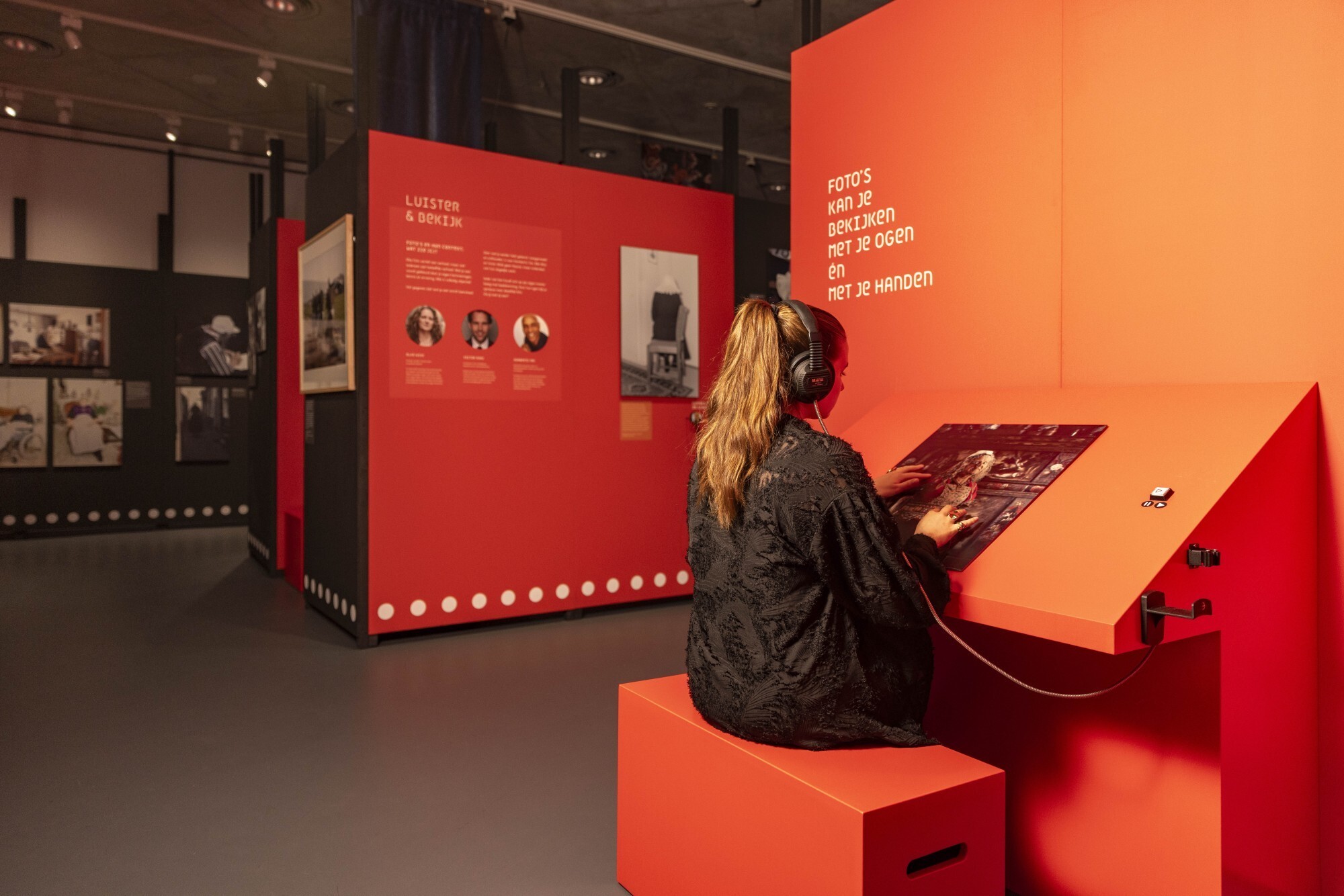 Bezoeker die relieffoto van Jimmy Nelson voelt en luistert naar audio