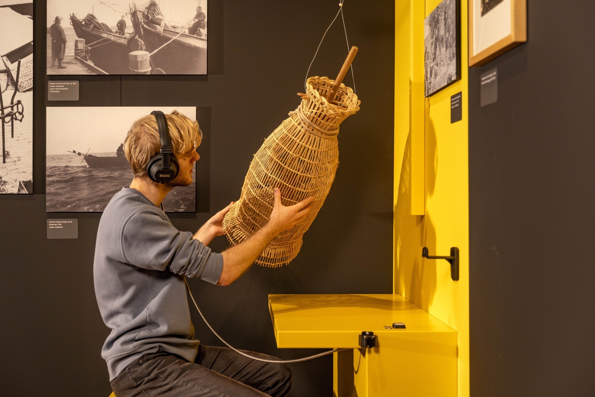 Bezoeker voelt aan een viskubbe, een voelobject op zaal