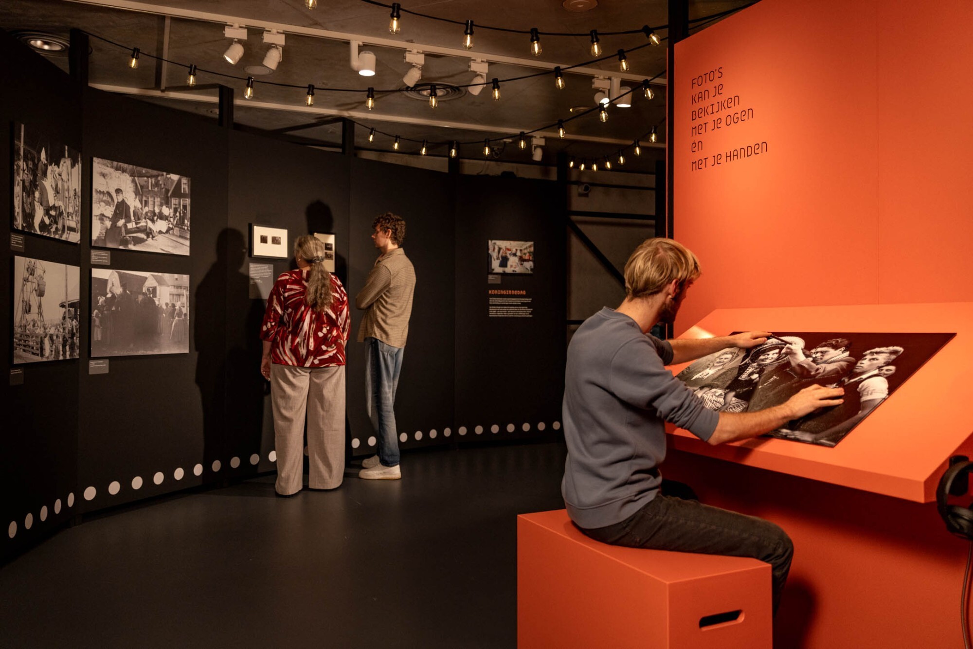 Bezoekers bekijken foto's van de tentoonstelling Voorbij de foto