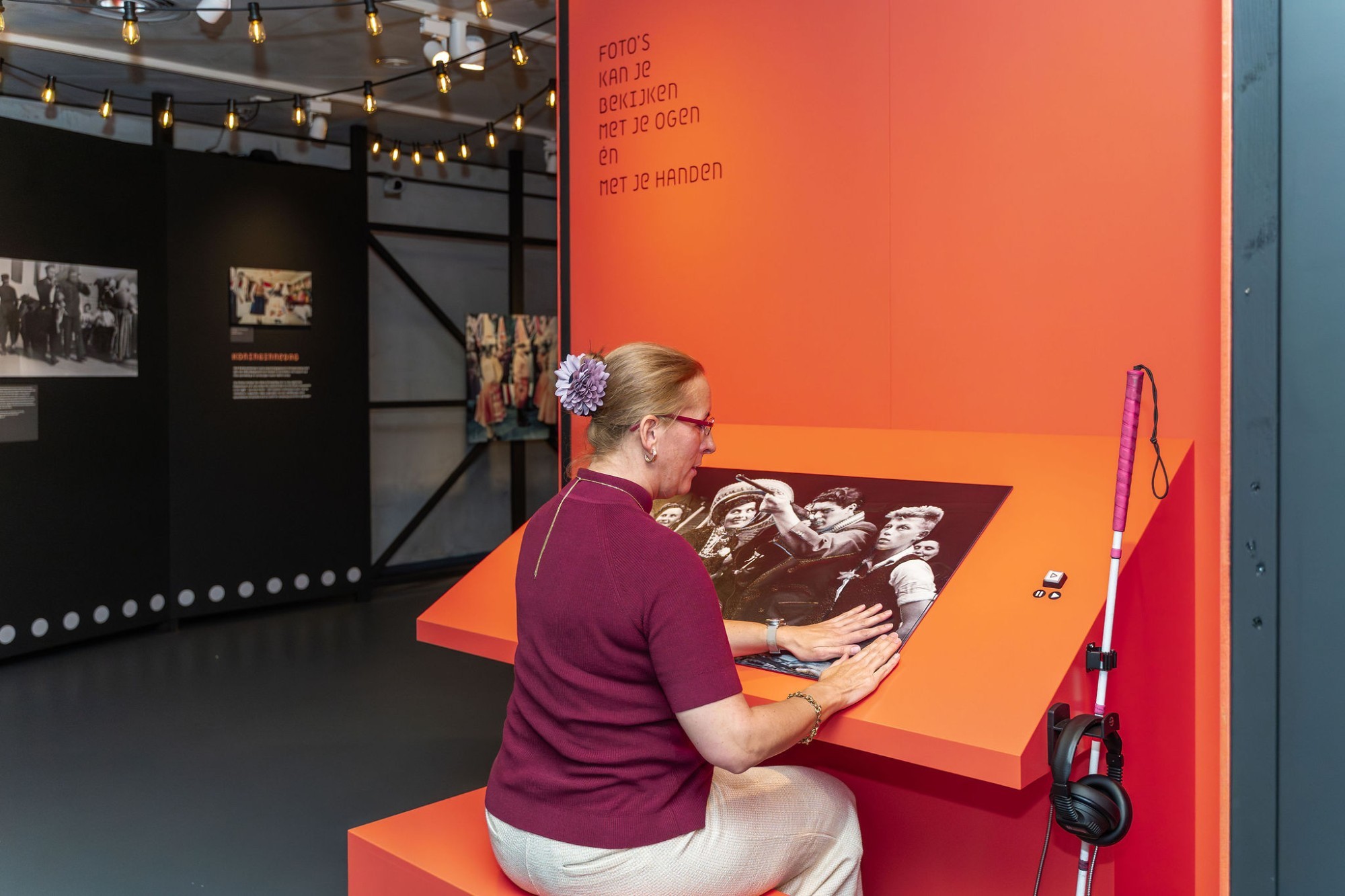 Een bezoeker met een visuele beperking verkent een relieffoto met haar handen