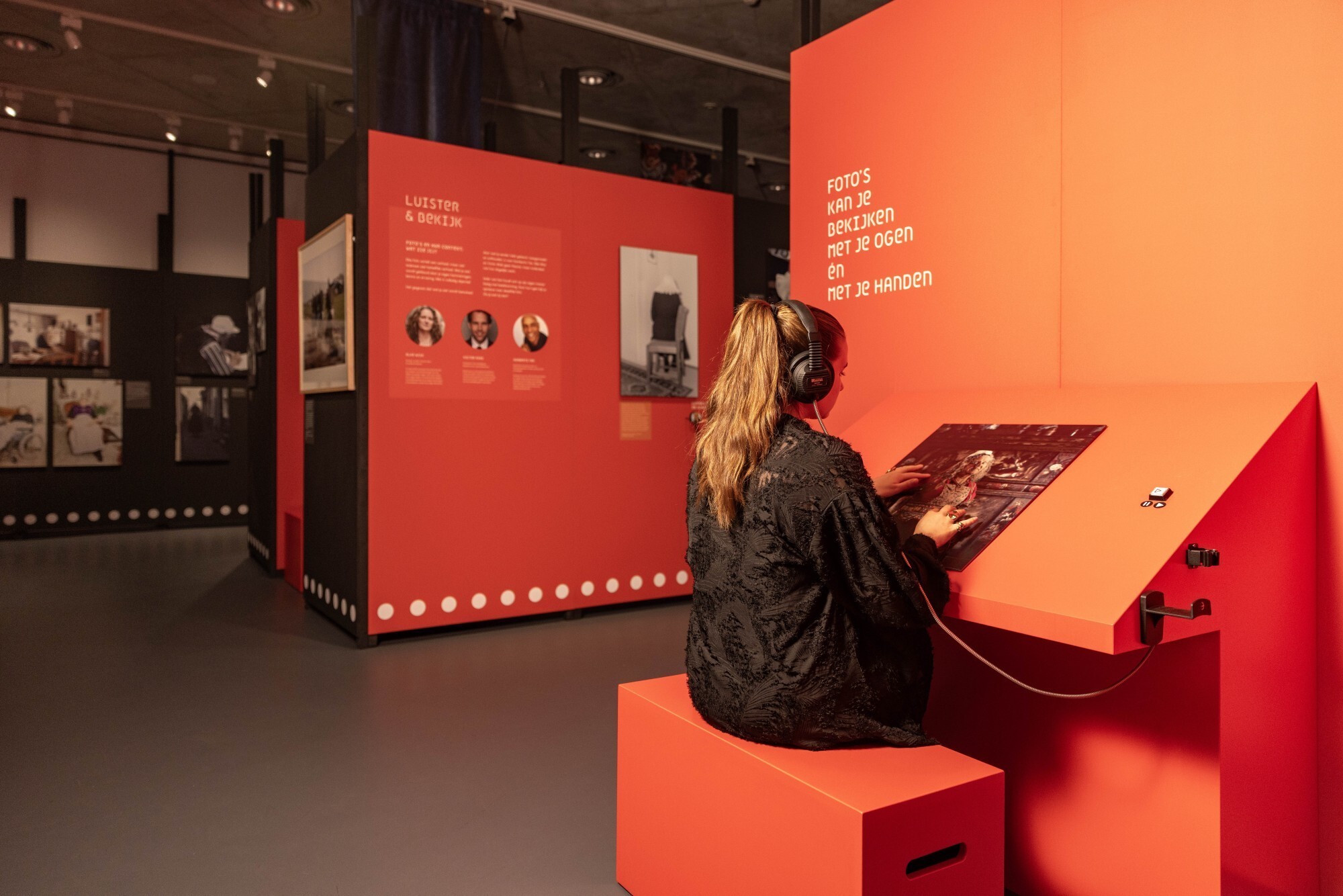 Bezoeker voelt aan een reliëffoto van Jimmy Nelson en luistert naar audio