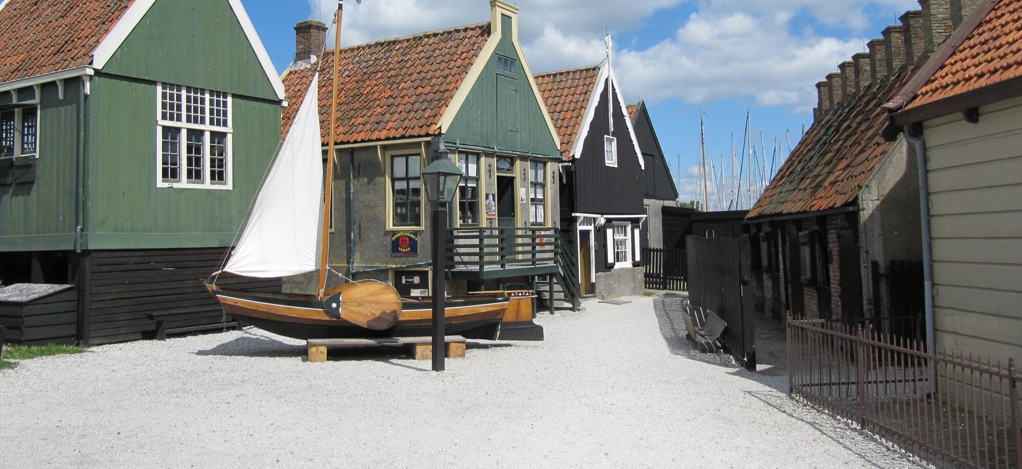 Houten visserschip tegen de achtergrond van Volendammer huisjes in het Zuiderzeemuseum