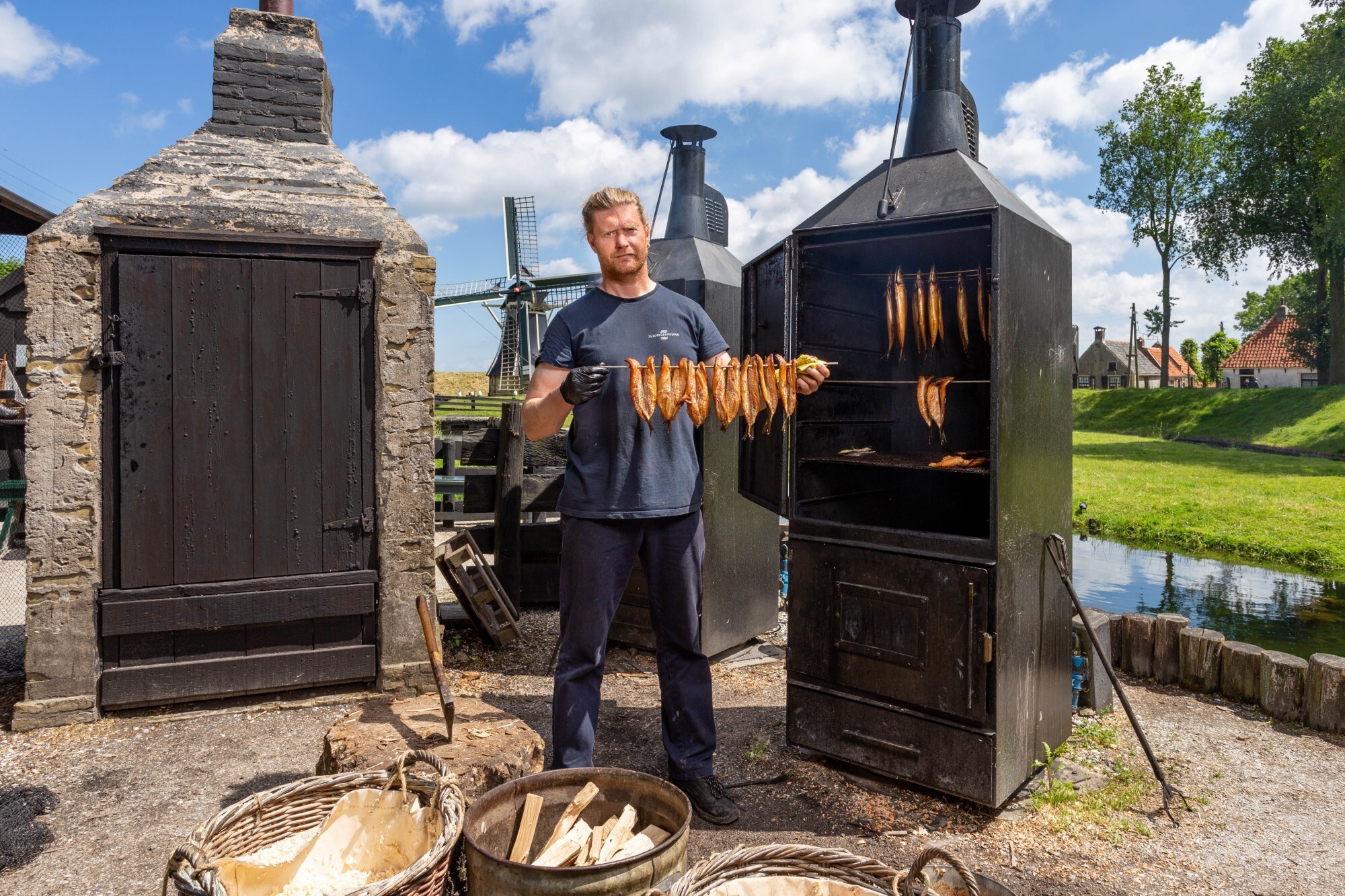 Een medewerker van het Zuiderzeemuseum laat gerookte vis zien.