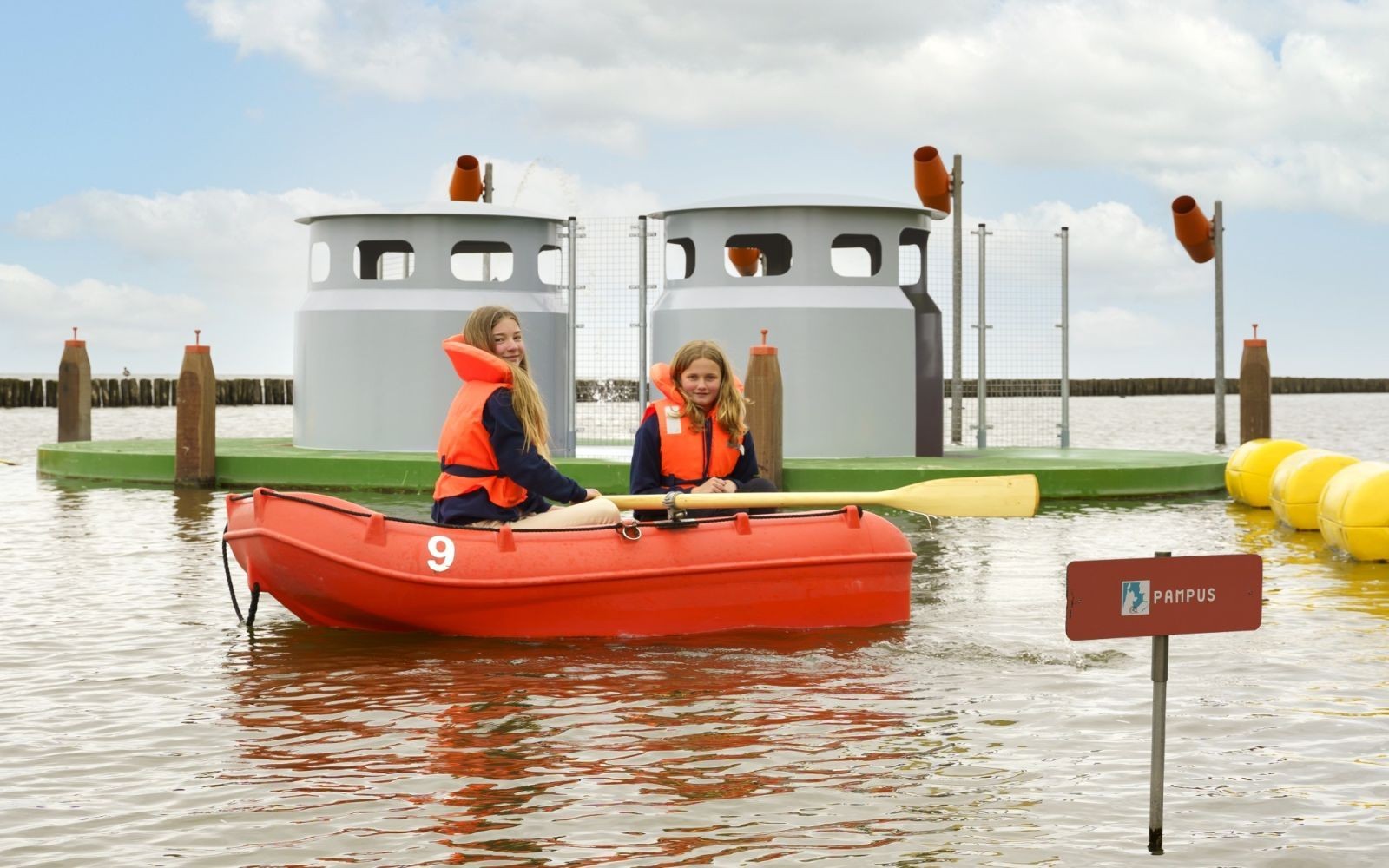 Twee meisjes in een roeibootje op het water.