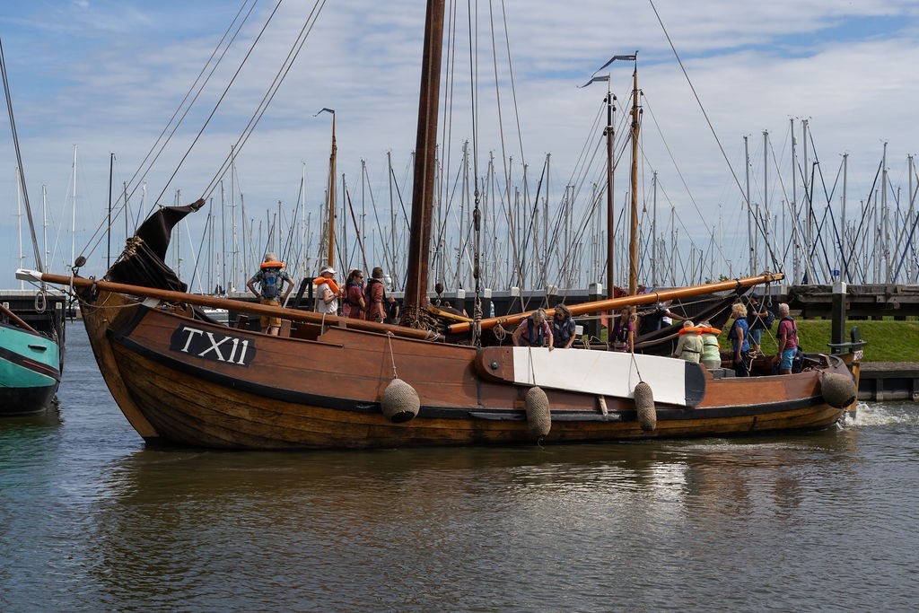 Houten visserschip TX11 vaart de haven van het Zuiderzeemuseum uit